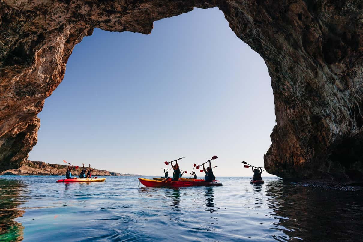 Kayaks in front of the Cala Falcó cliffs, next to Cala Varques